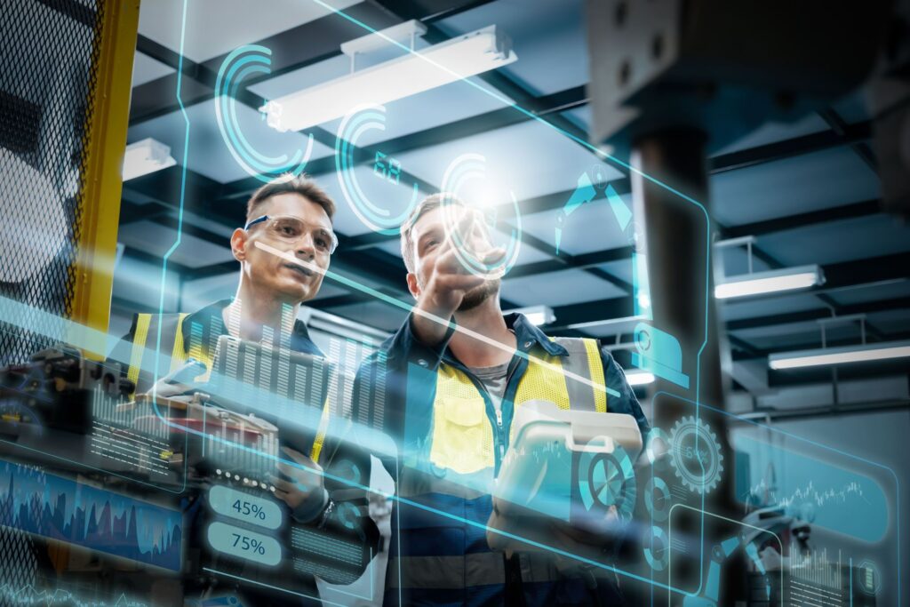 Due uomini, in fabbrica, che lavorano sulla manutenzione predittiva con l'aiuto dell'AI